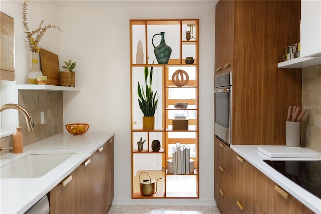 kitchen with sink, backsplash, and appliances with stainless steel finishes