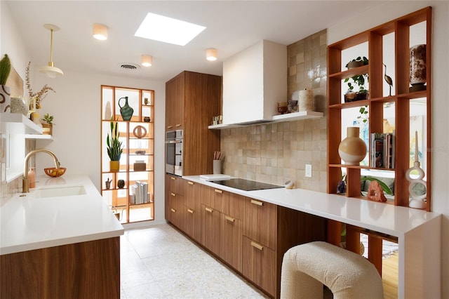 kitchen with sink, decorative light fixtures, a skylight, black electric stovetop, and oven