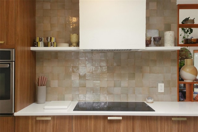 kitchen with tasteful backsplash, black electric stovetop, and oven