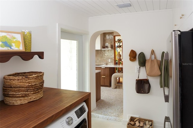 interior space with crown molding, wood ceiling, washer / clothes dryer, and carpet