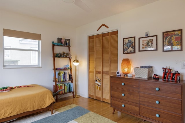 bedroom featuring ceiling fan, a closet, and light hardwood / wood-style flooring