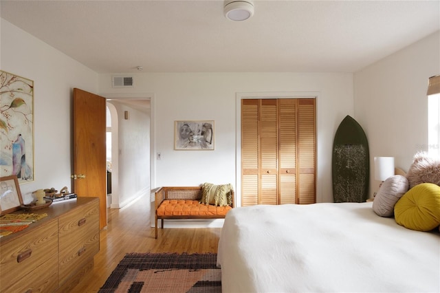 bedroom with light hardwood / wood-style floors and a closet