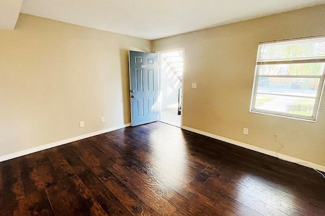 spare room with dark hardwood / wood-style flooring