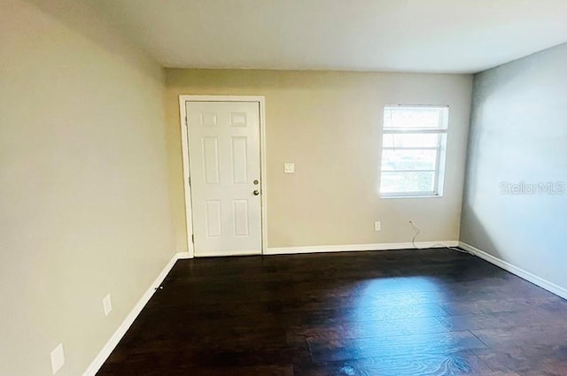 spare room featuring dark wood-type flooring