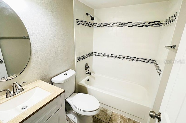 full bathroom featuring vanity, tiled shower / bath combo, and toilet