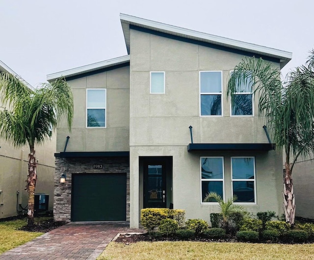 view of front of property featuring a garage and central air condition unit