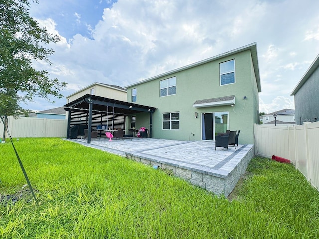 back of property featuring a yard and a patio