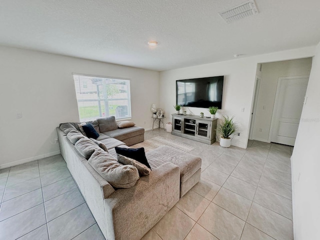 living room featuring a textured ceiling and light tile patterned floors