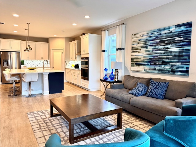 living room featuring sink and light wood-type flooring