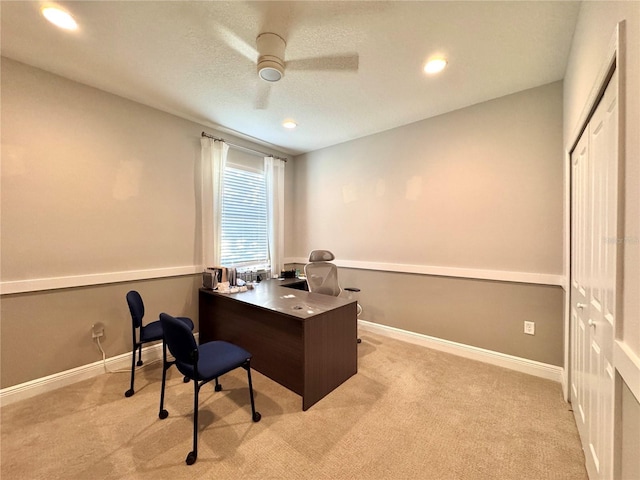 office space featuring ceiling fan, light colored carpet, and a textured ceiling