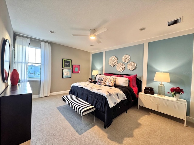 bedroom with light carpet, a textured ceiling, and ceiling fan