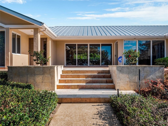 entrance to property with metal roof and stucco siding