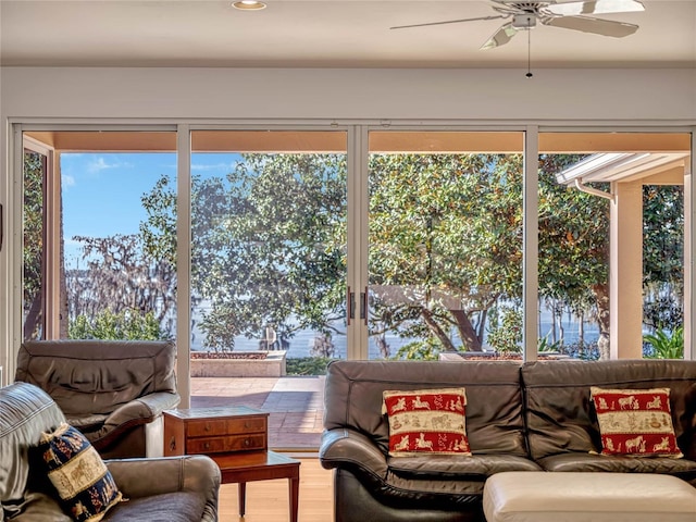 living room featuring wood finished floors, a ceiling fan, and a healthy amount of sunlight