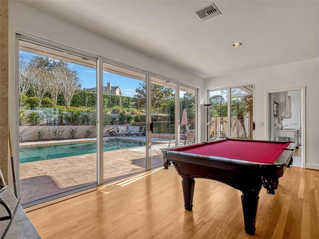 recreation room featuring plenty of natural light, wood finished floors, visible vents, and recessed lighting