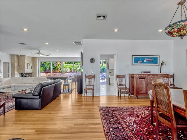 living room featuring light wood-style flooring, visible vents, and recessed lighting