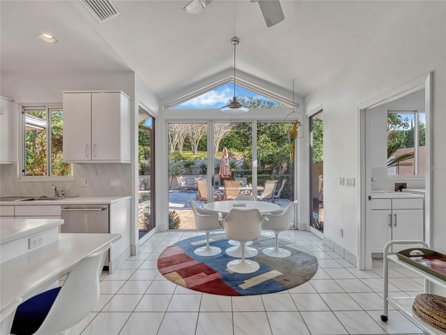 dining area featuring visible vents, vaulted ceiling, and light tile patterned floors