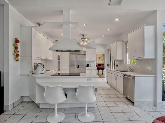 kitchen featuring visible vents, light countertops, backsplash, and built in appliances