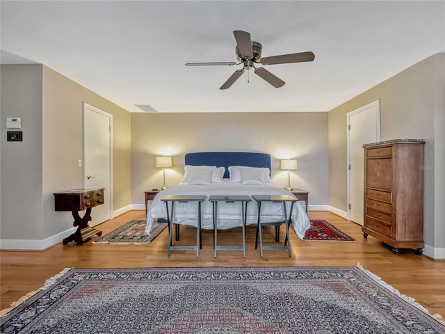 bedroom with wood finished floors, a ceiling fan, and baseboards