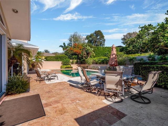 view of patio with a fenced backyard, outdoor dining area, and a fenced in pool