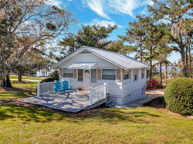 exterior space with metal roof and a front lawn