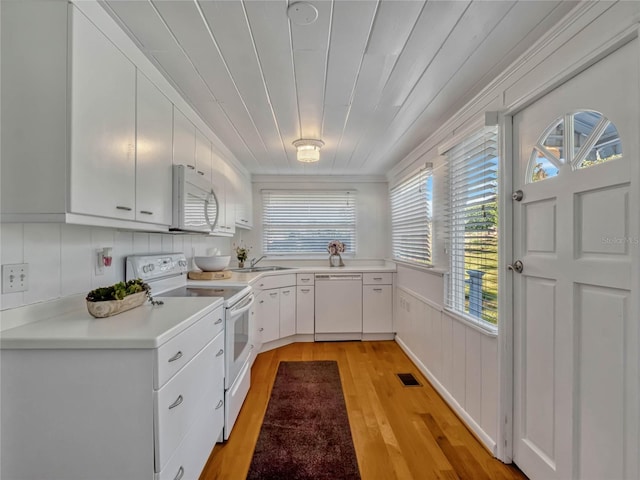 kitchen featuring white appliances, light countertops, a sink, and white cabinets