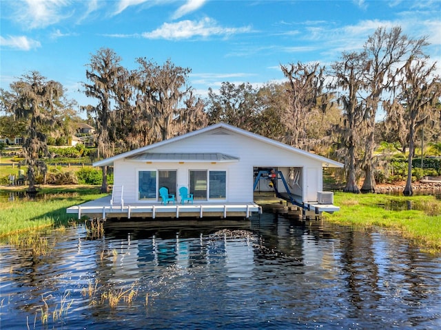 rear view of property featuring a water view, boat lift, and central AC unit