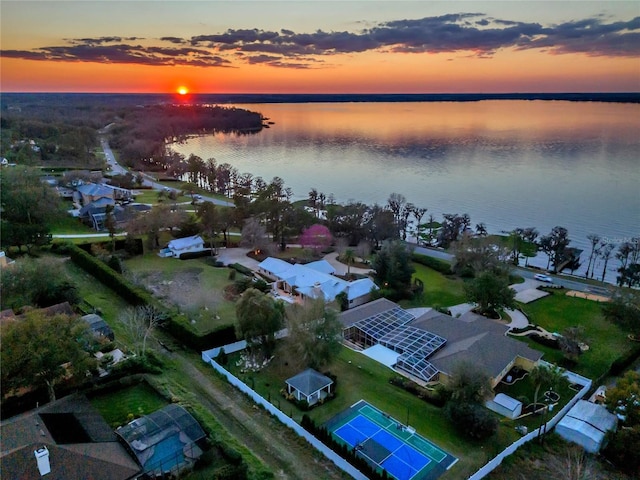 aerial view at dusk featuring a water view