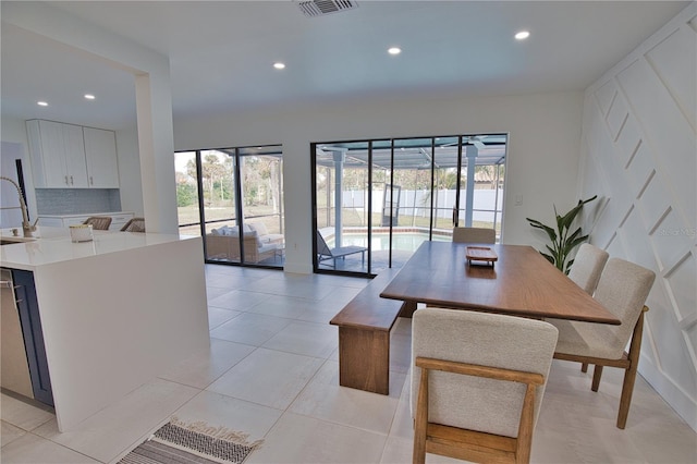 tiled dining space featuring a healthy amount of sunlight and sink