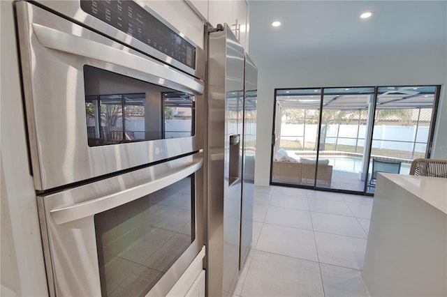 kitchen featuring light tile patterned floors, white cabinets, and appliances with stainless steel finishes