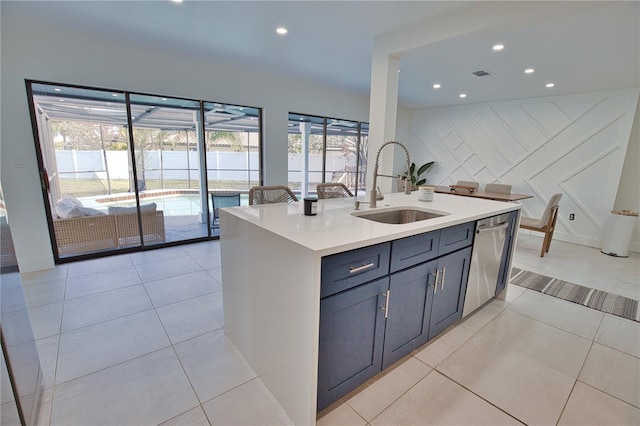 kitchen featuring light tile patterned flooring, stainless steel dishwasher, a kitchen island with sink, and sink