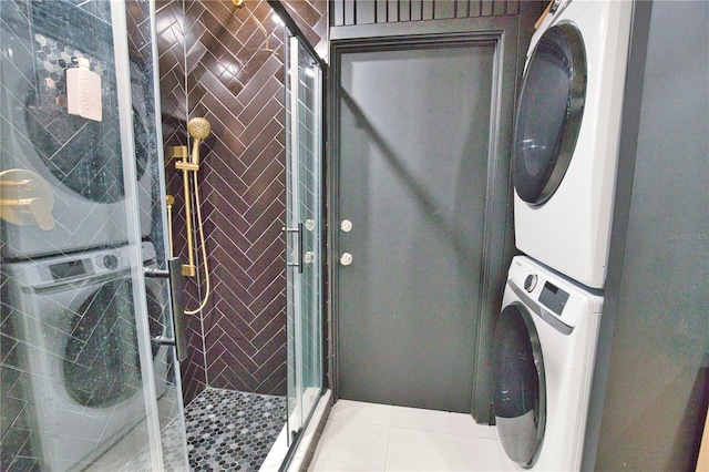 laundry room featuring stacked washer and clothes dryer and light tile patterned floors