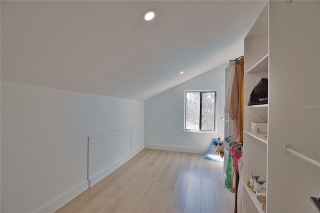 additional living space with lofted ceiling and light wood-type flooring