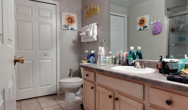 bathroom with vanity, tile patterned flooring, toilet, and walk in shower