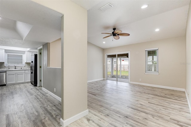 unfurnished room with light wood-style flooring, visible vents, and baseboards