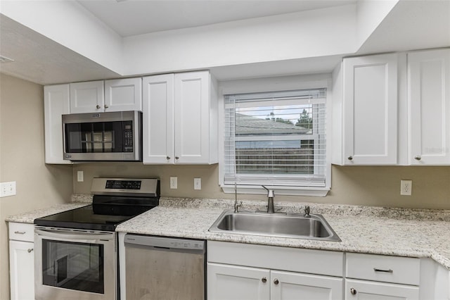 kitchen with visible vents, stainless steel appliances, a sink, and white cabinetry