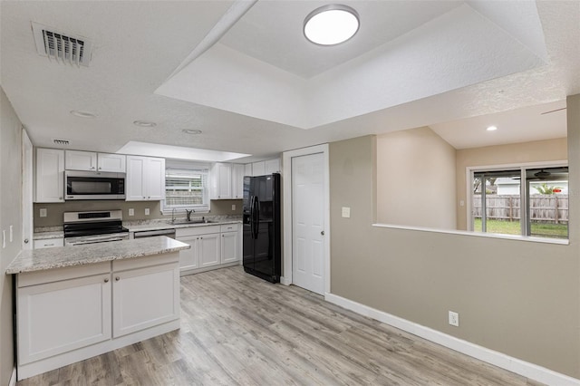 kitchen featuring baseboards, visible vents, appliances with stainless steel finishes, and a sink