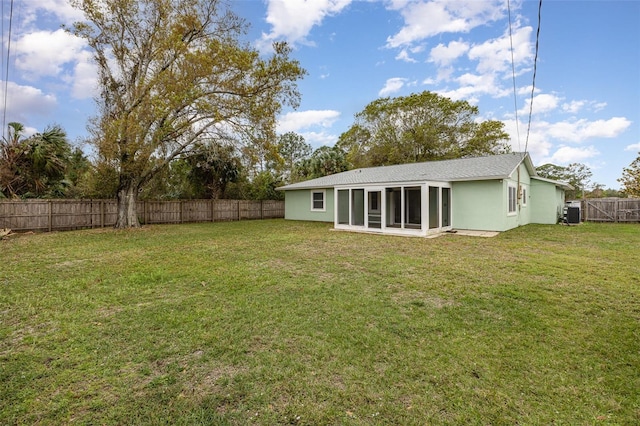 view of yard featuring a sunroom and a fenced backyard