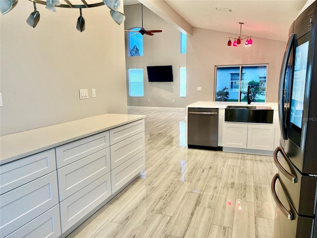 kitchen with sink, hanging light fixtures, black refrigerator, stainless steel dishwasher, and white cabinets