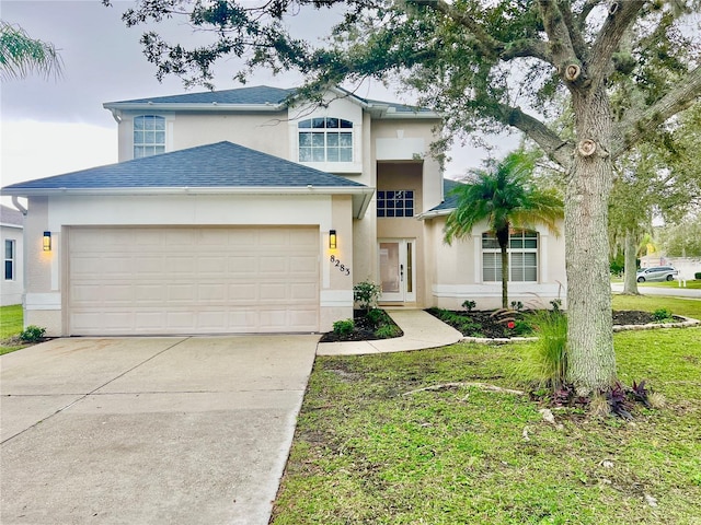 8283 47th Street Cir E, Palmetto, FL 34221 - traditional-style house featuring stucco siding, driveway, a garage, a shingled roof, and a front yard