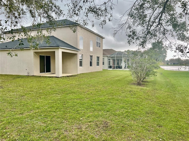 8283 47th Street Cir E, Palmetto, FL 34221 - back of property featuring stucco siding, a yard, a shingled roof, and a patio