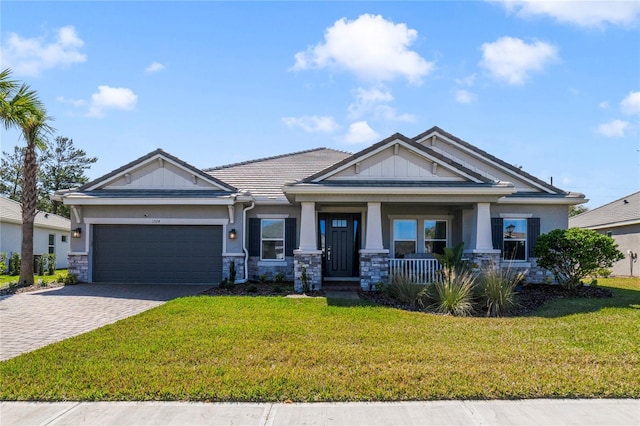 craftsman inspired home featuring a garage, a porch, and a front yard