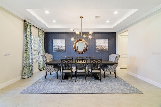 dining room featuring ornamental molding, a tray ceiling, a chandelier, and light tile patterned floors