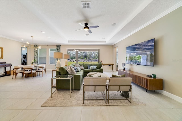 tiled living room featuring crown molding, a tray ceiling, ceiling fan with notable chandelier, and a textured ceiling