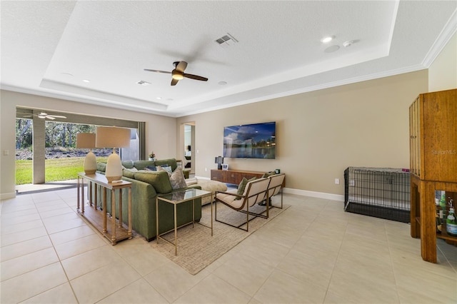 tiled living room featuring ceiling fan, a raised ceiling, and a textured ceiling