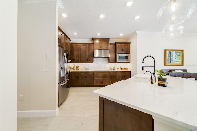 kitchen with sink, appliances with stainless steel finishes, hanging light fixtures, light stone counters, and ornamental molding