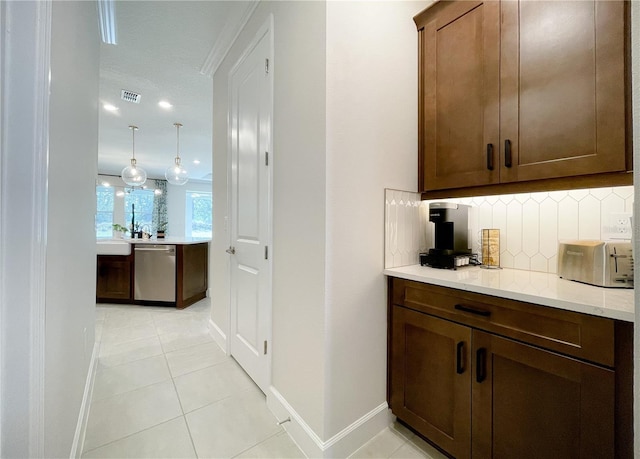 bar with tasteful backsplash, light tile patterned floors, dishwasher, pendant lighting, and light stone countertops