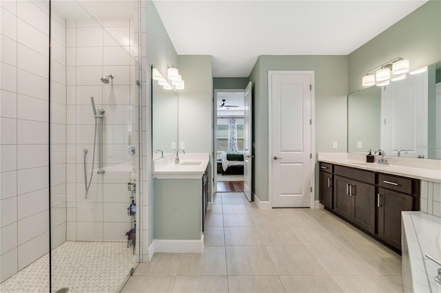 bathroom featuring vanity, tile patterned flooring, and a tile shower