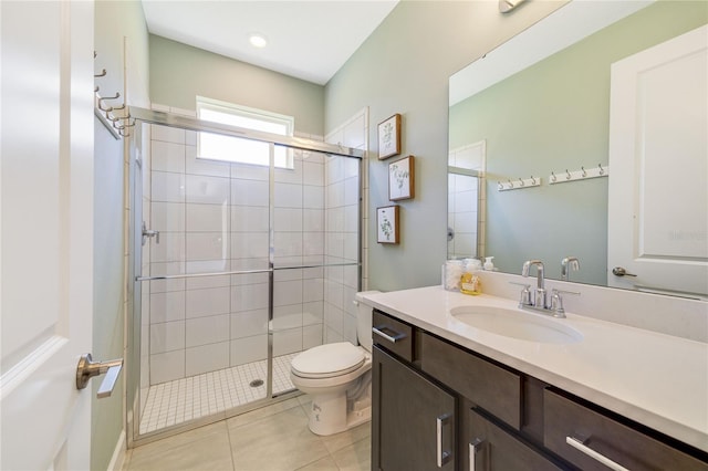 bathroom featuring vanity, a shower with door, tile patterned floors, and toilet