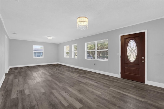 foyer featuring an inviting chandelier and dark hardwood / wood-style flooring