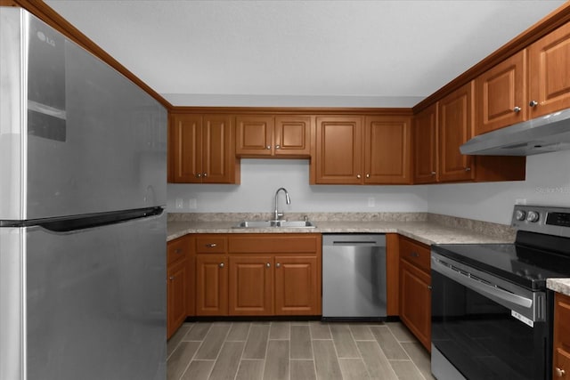 kitchen with stainless steel appliances, sink, and light stone counters